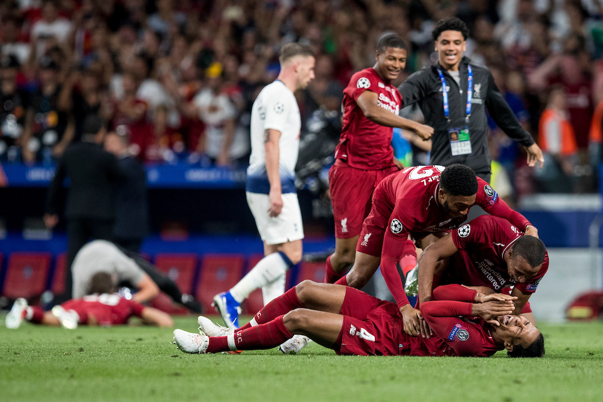 MADRID, SPAIN - SATURDAY, JUNE 1, 2019: Liverpool's Virgil van Dijk collapses to the pitch at the final whistle as team-mates Joel Matip and Joe Gomez embrace him as they celebrate a 2-0 victory in the UEFA Champions League Final match between Tottenham Hotspur FC and Liverpool FC at the Estadio Metropolitano. (Pic by Paul Greenwood/Propaganda)