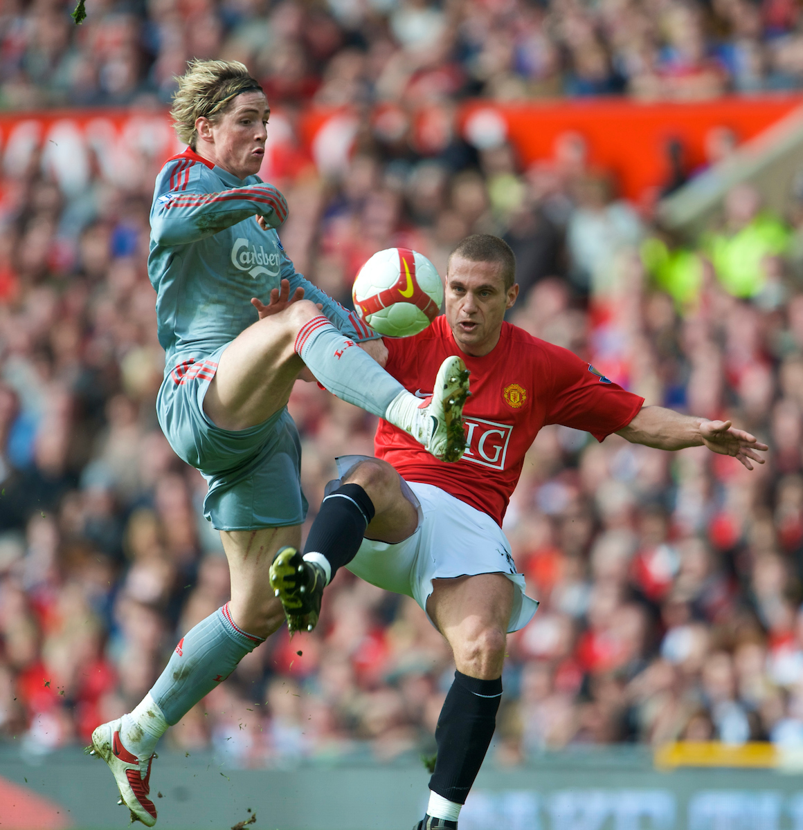 MANCHESTER, ENGLAND - Saturday, March 14, 2009: Liverpool's Fernando Torres powers past Manchester United's hapless Nemanja Vidic on his way to scoring the second goal during the Premiership match at Old Trafford. (Photo by David Rawcliffe/Propaganda)