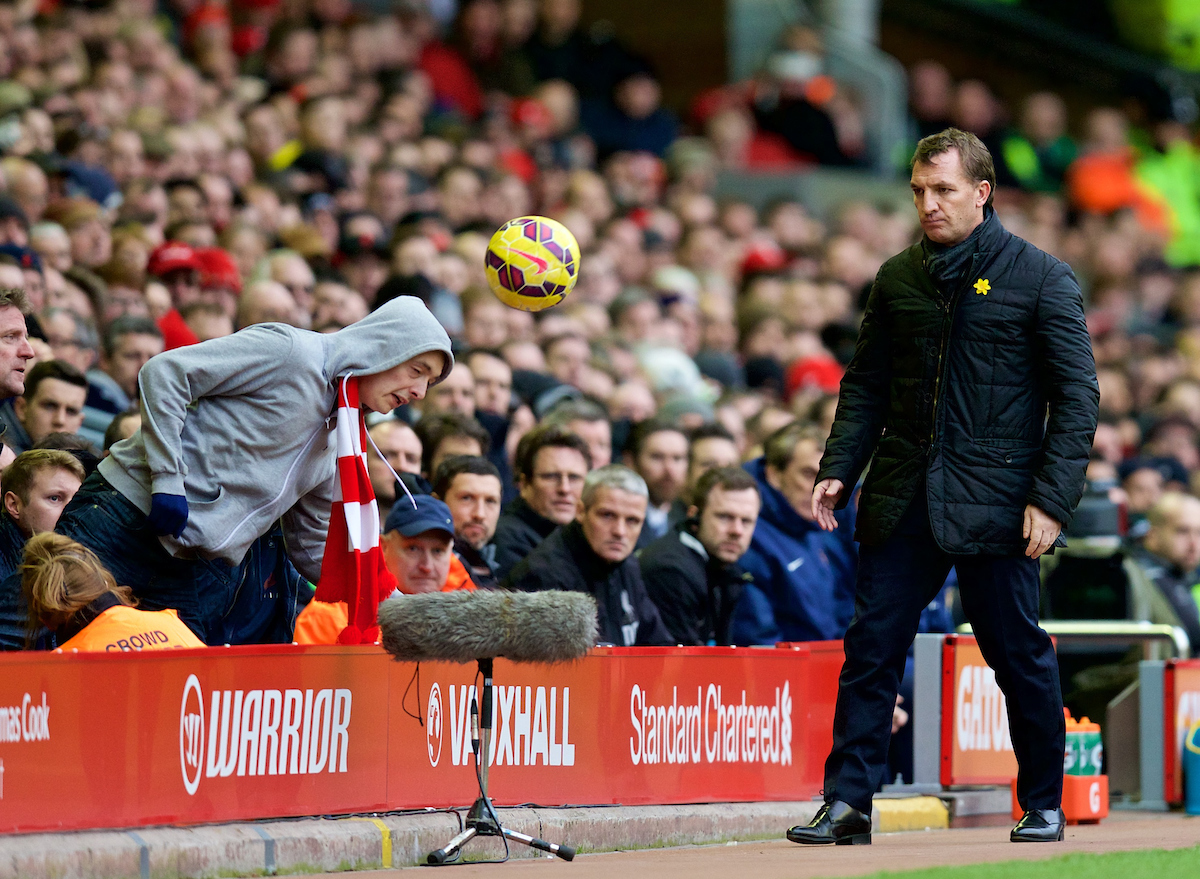 LIVERPOOL, ENGLAND - Sunday, March 1, 2015: Liverpool's manager Brendan Rodgers goes to retrieve the ball but is beaten to it by a supporter during the Premier League match against Manchester City at Anfield. (Pic by David Rawcliffe/Propaganda)