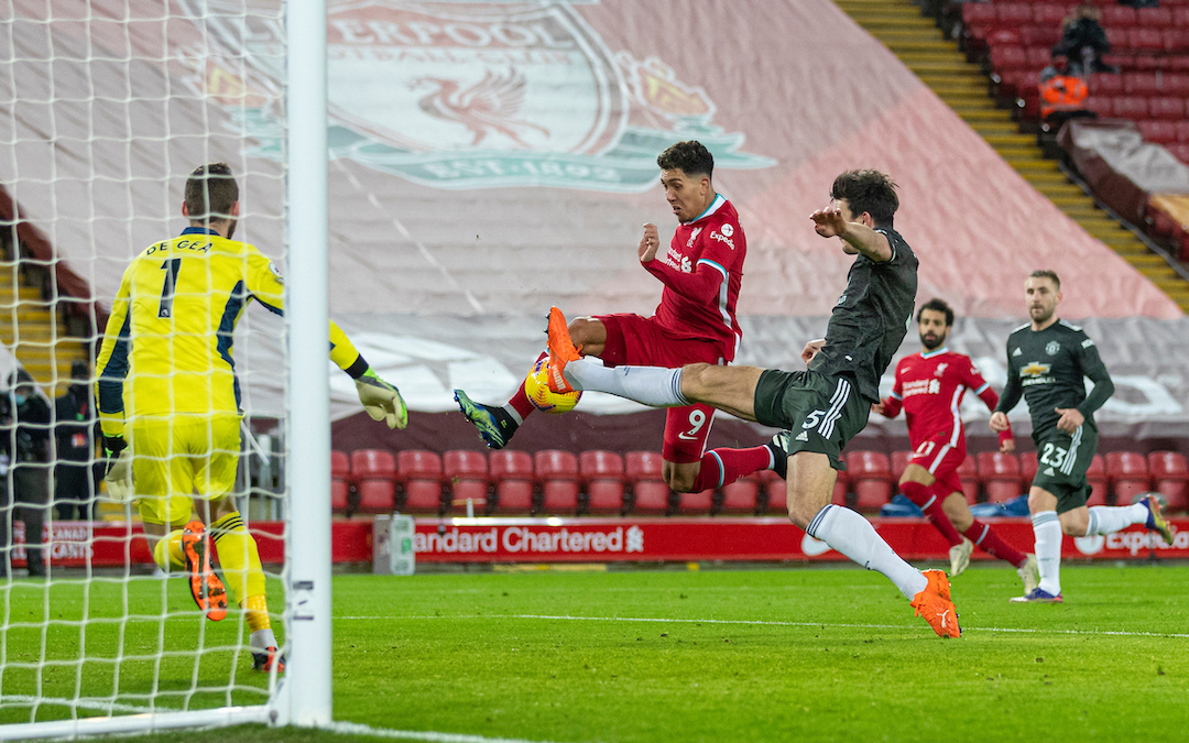 Liverpool's Roberto Firmino shoots wide under pressure from Manchester United's captain Harry Maguire during the FA Premier League match between Liverpool FC and Manchester United FC at Anfield