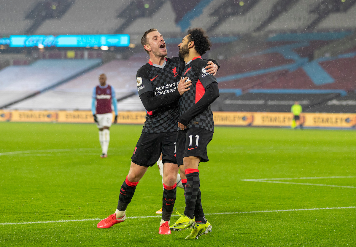 Liverpool's Mohamed Salah celebrates with team-mate captain Jordan Henderson (L) after scoring the second goal during the FA Premier League match between West Ham United FC and Liverpool FC at the London Stadium