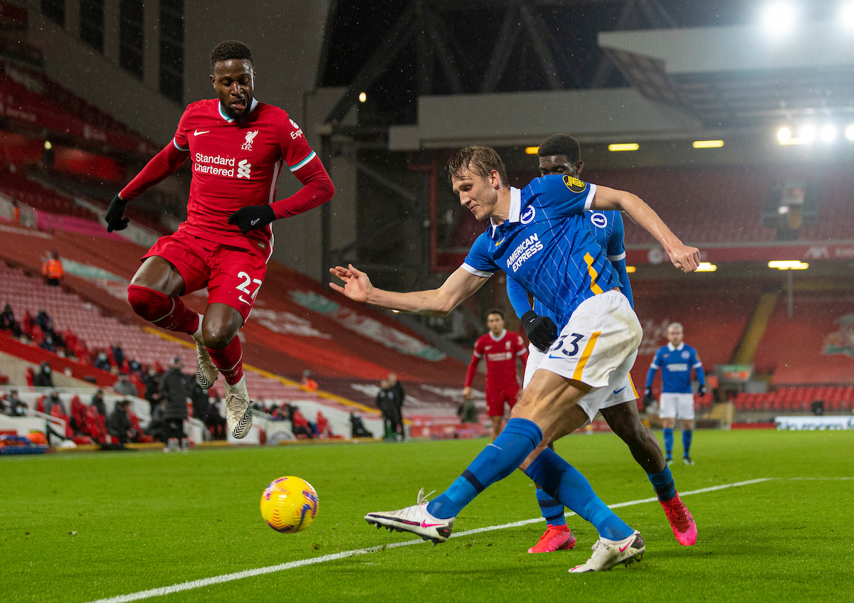 Brighton & Hove Albion's Dan Burn clears the ball under pressure from Liverpool's Divock Origi during the FA Premier League match between Liverpool FC and Brighton & Hove Albion FC at Anfield