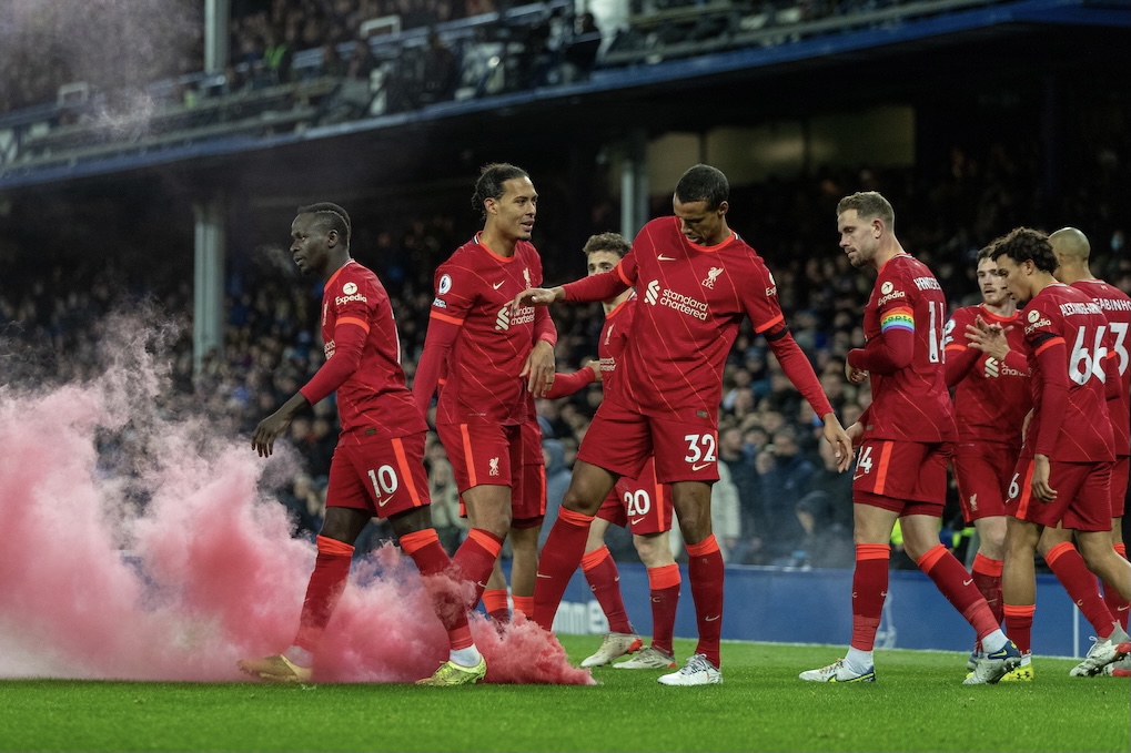 Liverpool's players look at a smoke bomb on the pitch as Mohamed Salah celebrates after scoring the third goal during the FA Premier League match between Everton FC and Liverpool FC, the 239th Merseyside Derby, at Goodison Park