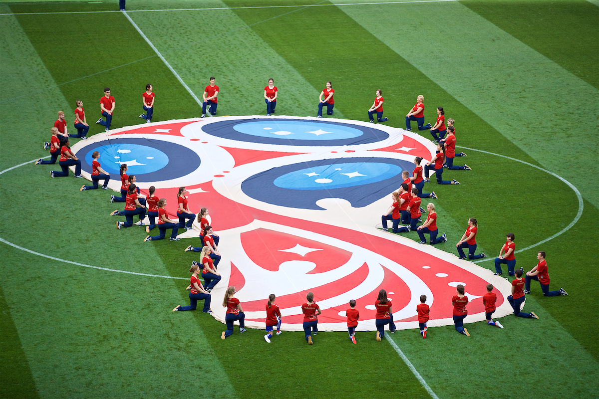 Volunteers unveil a huge World Cup logo banner on the pitch before the FIFA World Cup Russia 2018 Round of 16 match between Spain and Russia at the Luzhniki Stadium