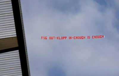 A plane flies a banner over the stadium with the message "FSG Out - Klopp In - Enough is Enough" ahead of the FA Premier League match between Liverpool FC and Manchester United FC at Anfield
